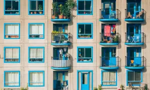 Elegancki blok z niebieskimi ramami okien i balkonami. Zastanawiasz się, do kogo napisać skargę na spółdzielnię mieszkaniową?