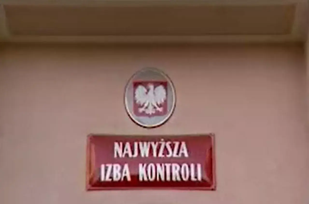 Tablica z napisem "Najwyższa Izba Kontroli" i godłem Polski.